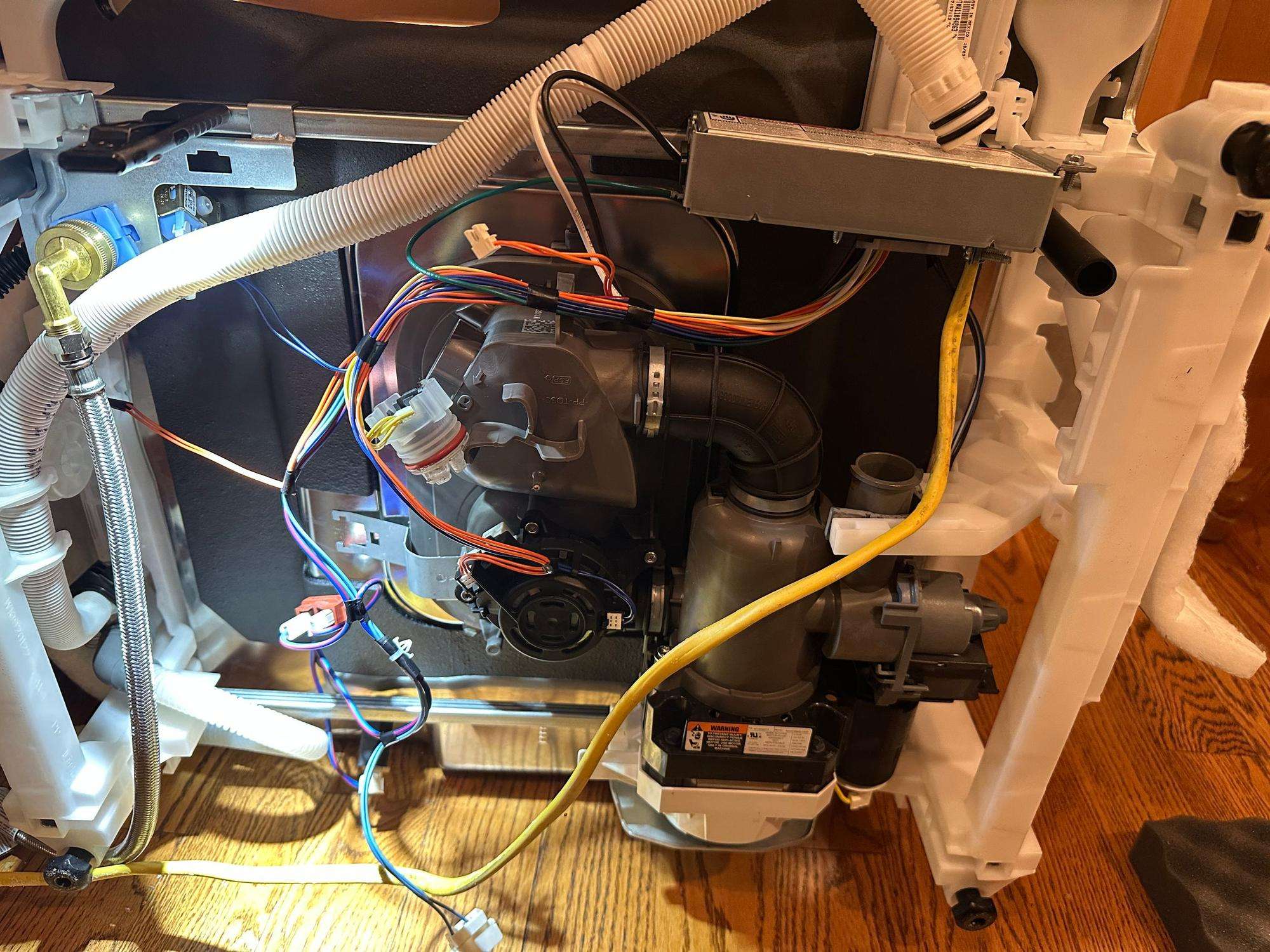 Dishwasher drain pump and motor assembly visible from underneath the unit