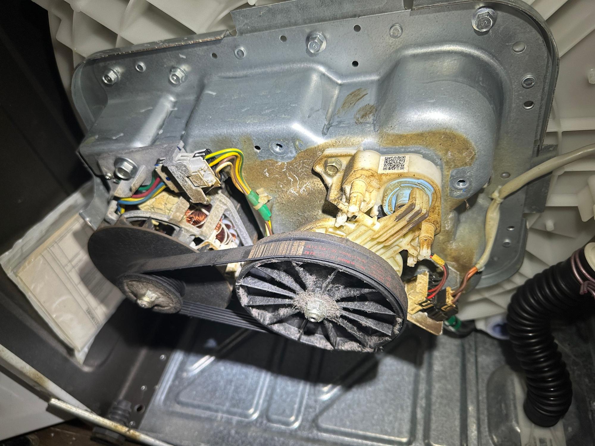 Inside a top-load washer showing the gear case and drive components. Wear in this area causes shaking and leaks